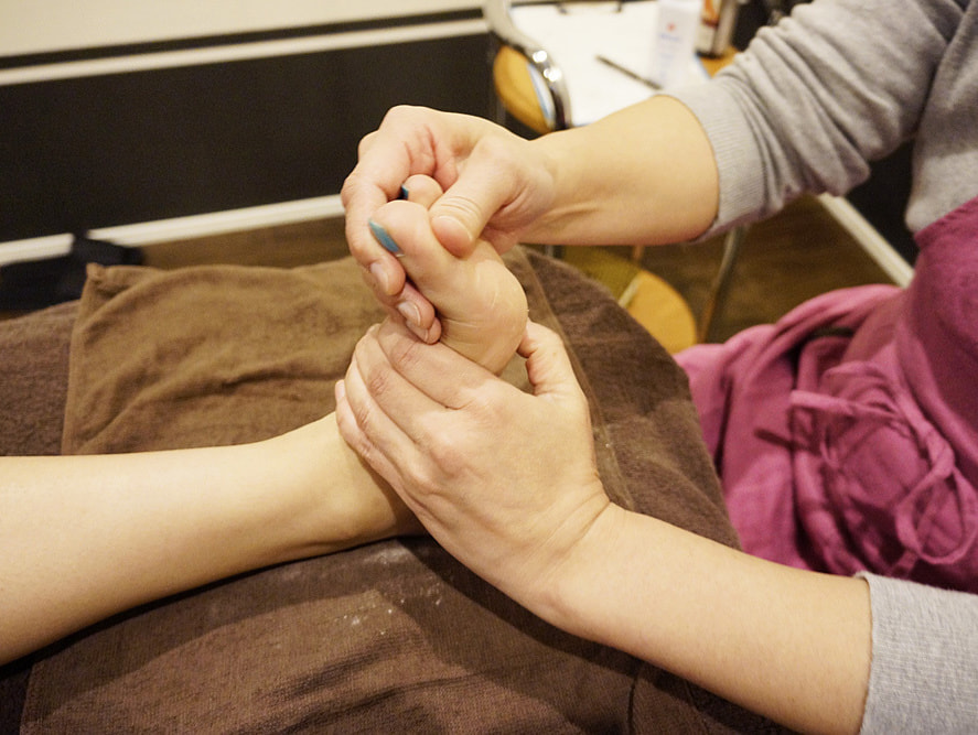 パウダーで足の親指を施術している